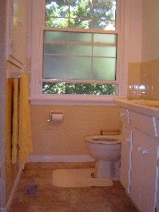 Bright sunny bathroom with new flooring and a handy linen closet 