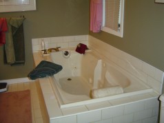 The ensuite enjoys a deep whirlpool tub and ceramic flooring. 