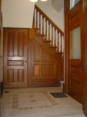 Formal front foyer with decorative ceramic flooring and natural woodwork