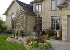 Beautiful interlocking brick walkway and elegant landscaping greet you at the entrance of this home 